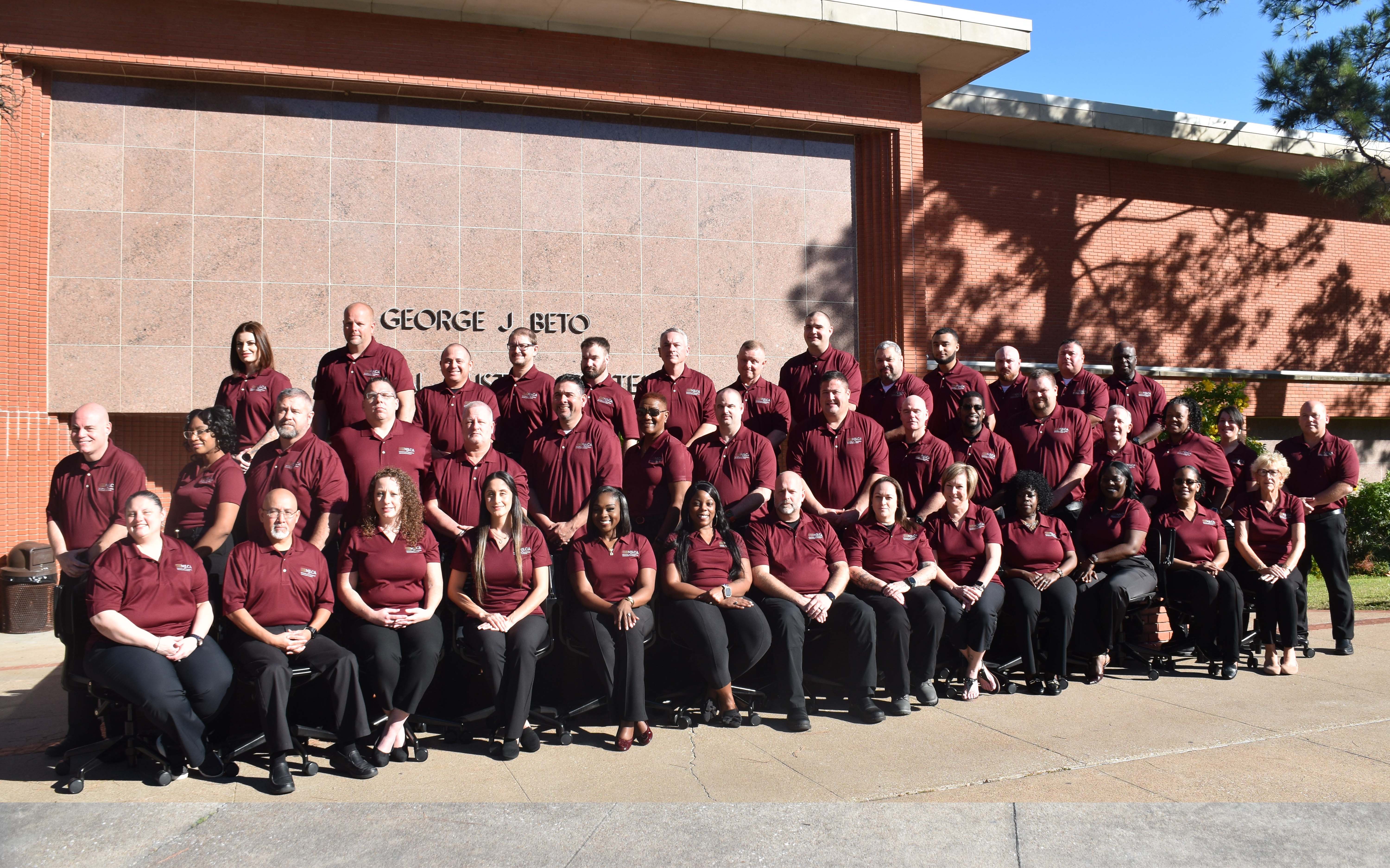 Image: Class #54 grouped outside a red brick building.