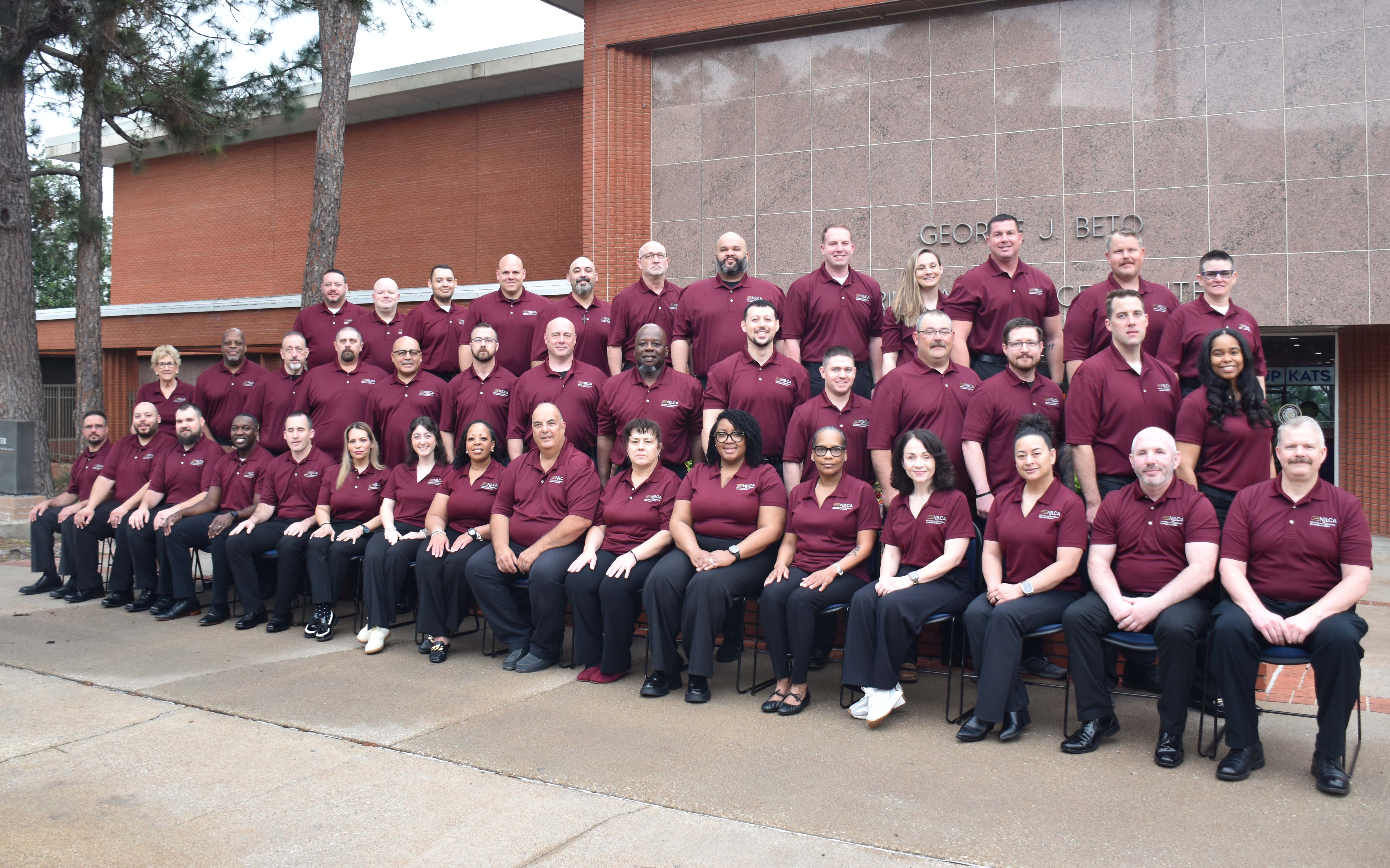 Image: Class #55 grouped outside a red brick building.