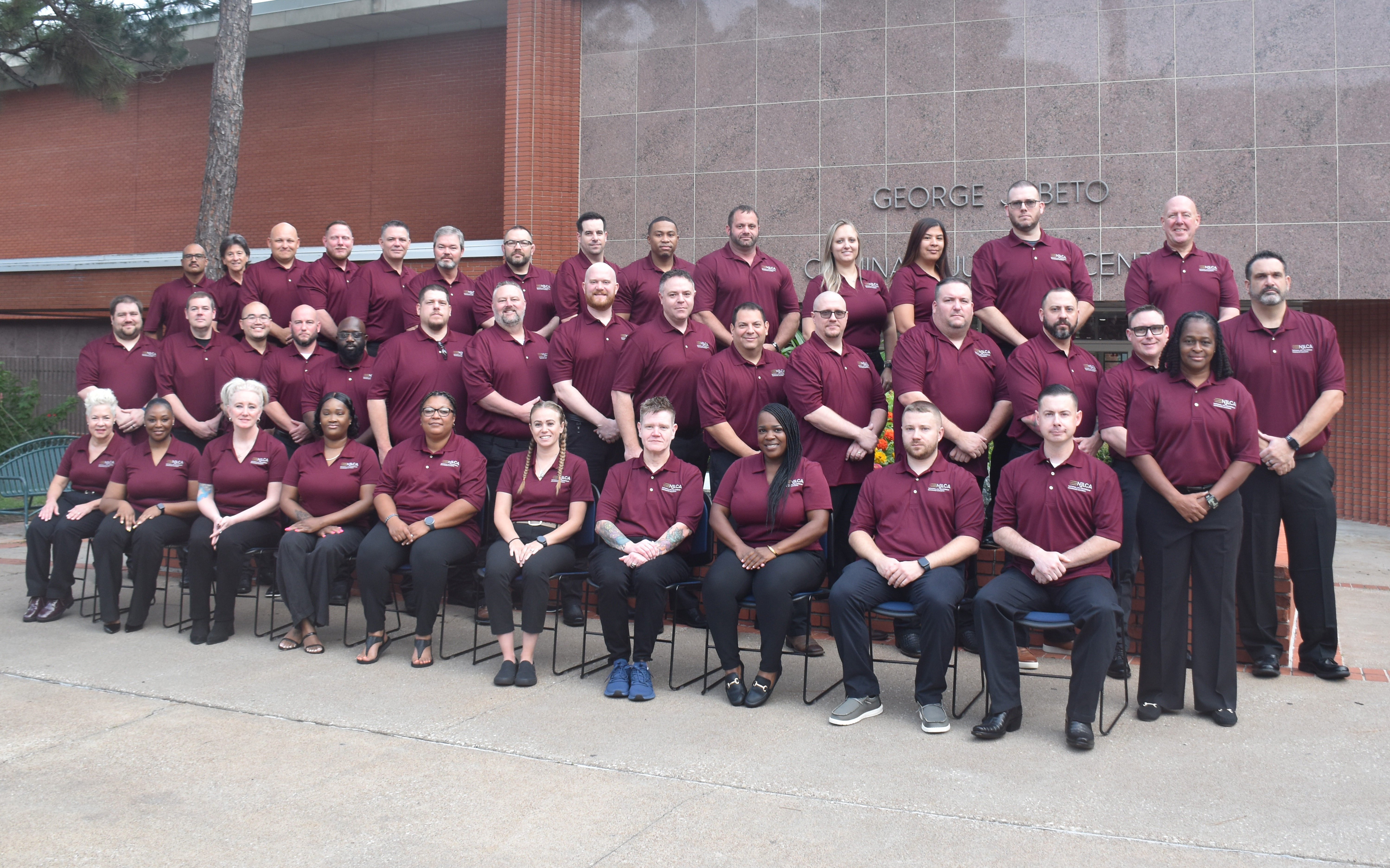 Image: Class #56 grouped outside a red brick building.