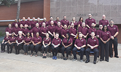 Image: Class #56 grouped in front of red brick building.